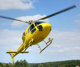 Yellow helicopter flying under blue sky Stock Photo 02