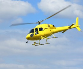Yellow helicopter flying under blue sky Stock Photo 03