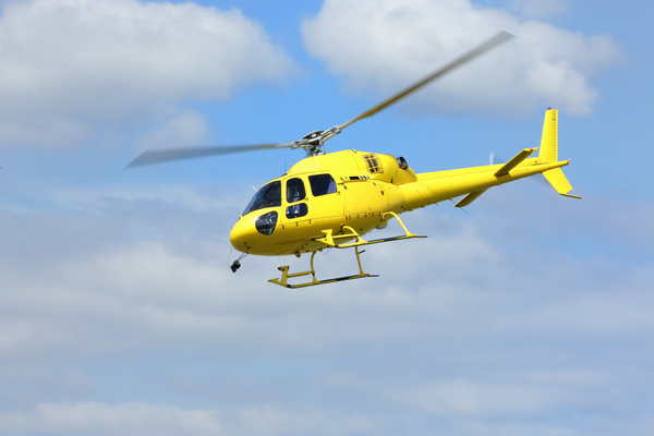 Yellow helicopter flying under blue sky Stock Photo 03
