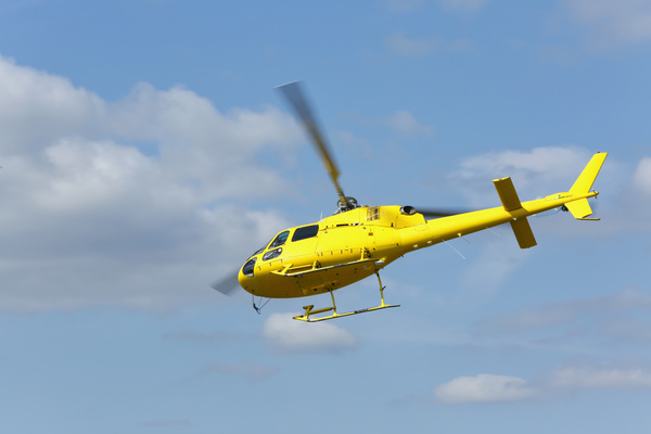 Yellow helicopter flying under blue sky Stock Photo 05
