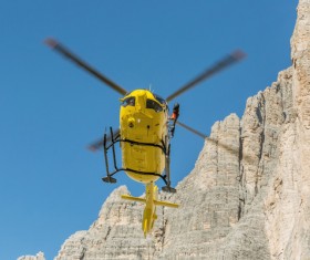 Yellow helicopters walk through the dolomite Stock Photo