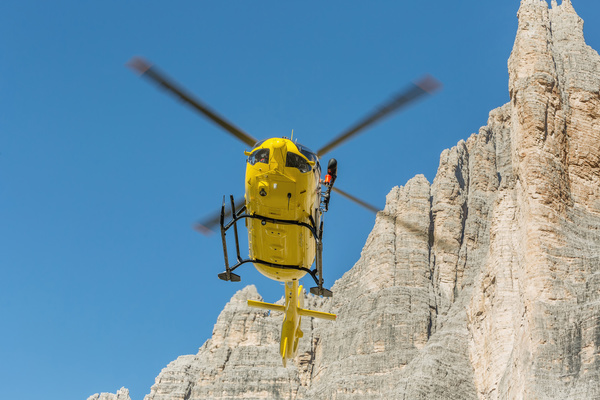 Yellow helicopters walk through the dolomite Stock Photo