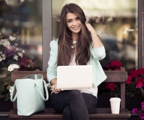 Young woman sitting on a stool using a laptop
