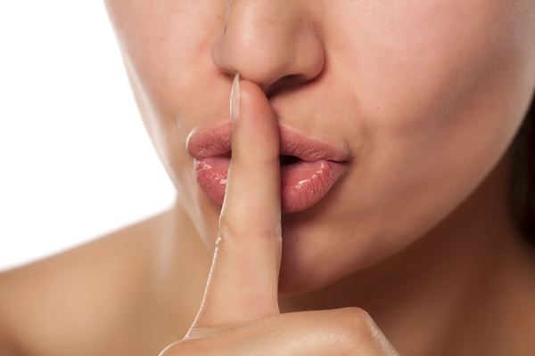 woman expressing a desire for silence or secret on white