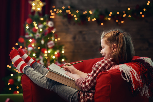 Christmas girl sitting on the sofa drawing Stock Photo