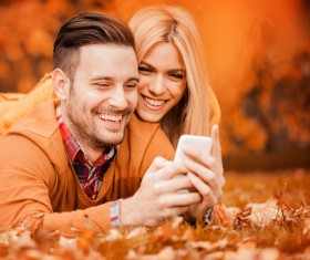Couple looking at cell phone in autumn park Stock Photo