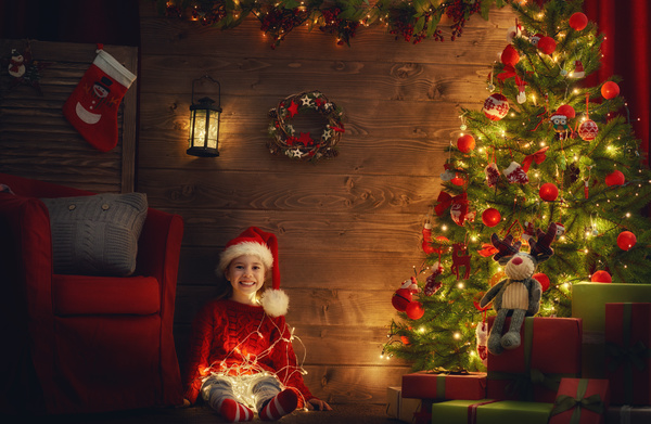 Girl with Christmas tree covered with gifts Stock Photo