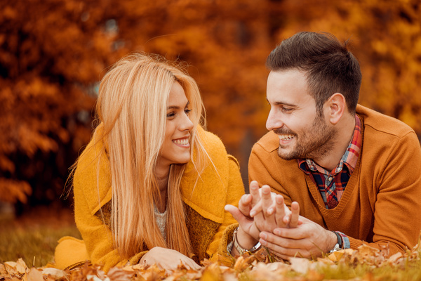 Happy couple on the grass holding hands chat Stock Photo