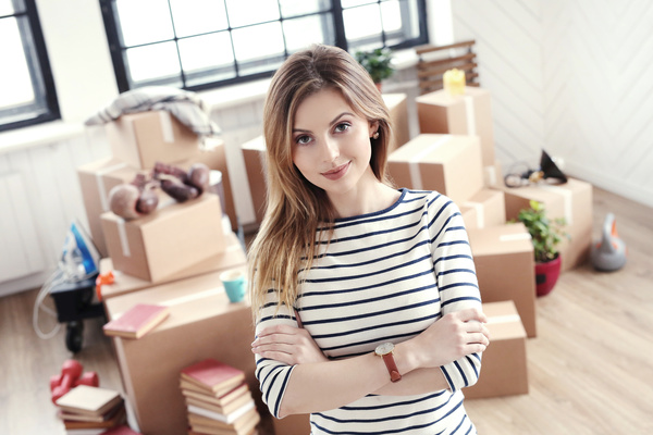 Pretty woman with boxes behind Stock Photo