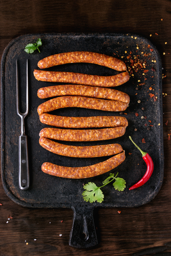 Sausage with red peppers on the baking tray