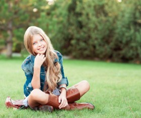 Sitting on a park grass blonde little girl