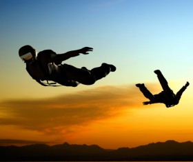 Sunset and skydiving athletes Stock Photo