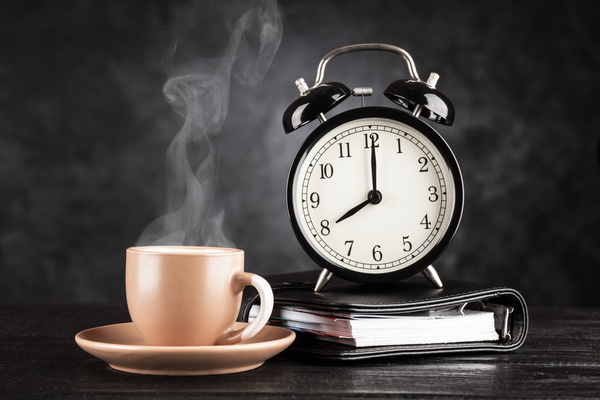 close up view of coffee maker, alarm clock and cup of coffee isolated on  red Stock Photo by LightFieldStudios