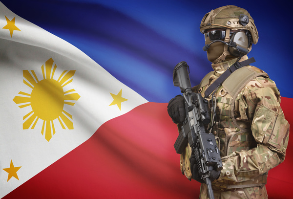 Filipino flag with heavily armed soldiers Stock Photo
