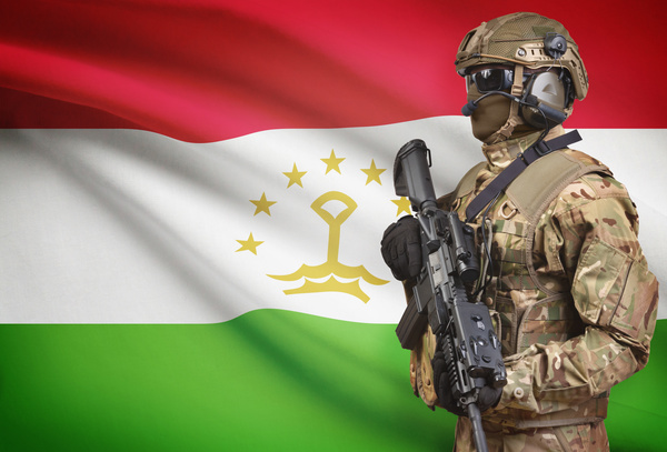 Flag of the Republic of Tajikistan and heavily armed soldiers