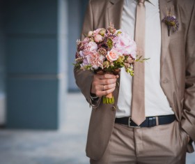 Hand holding the bouquet of the groom Stock Photo