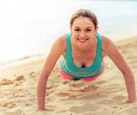 Woman doing push-ups on the beach Stock Photo