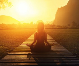 A woman meditating in the face of the sun Stock Photo