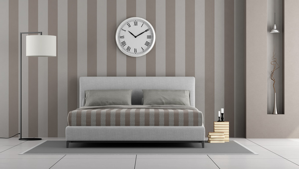 Simple bedroom with bed and wall clock Stock Photo