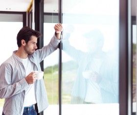 The handsome man drinking coffee in the window Stock Photo