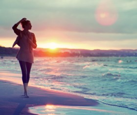Woman walking in the sand under the sunset HD picture