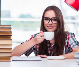 Young female student drinking coffee and books HD picture