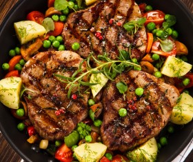 Grilled steak baked potatoes and vegetables Stock Photo