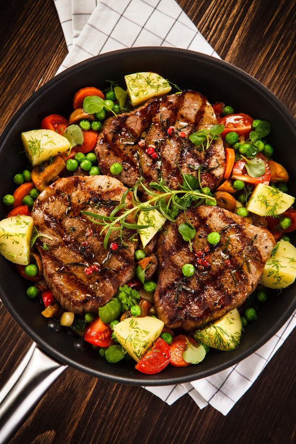 Grilled steak baked potatoes and vegetables Stock Photo