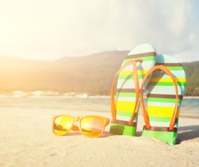 Slippers on the beach with sunglasses Stock Photo