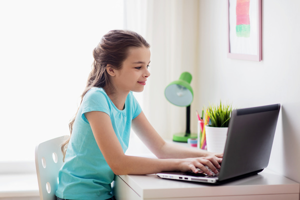 A little girl typing on a tablet Stock Photo