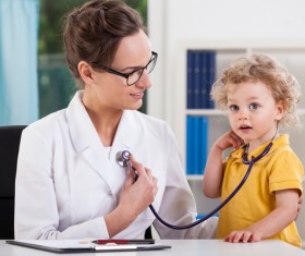 Coaxing children happy pediatric female doctor Stock Photo