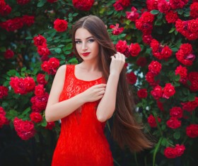 Girl wearing a red dress with red flowers background Stock Photo