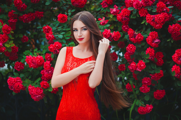 Girl wearing a red dress with red flowers background Stock Photo