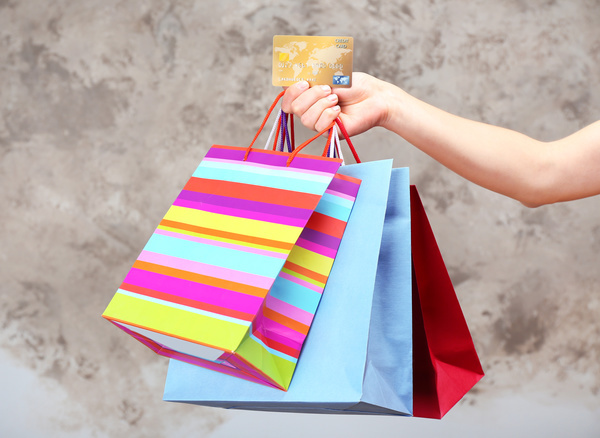 Holding a shopping bag with a bank card for a woman Stock Photo 01
