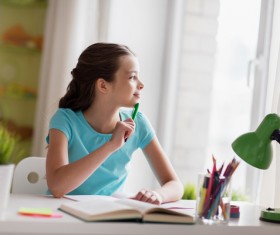 Learning little girl looking out the window Stock Photo