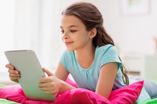 Play the little girl on the tablet Stock Photo