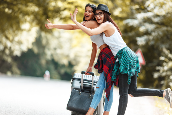 Two women who dragged the suitcase wanted a free ride Stock Photo