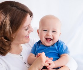 Happy mother laughing in the arms of the baby Stock Photo