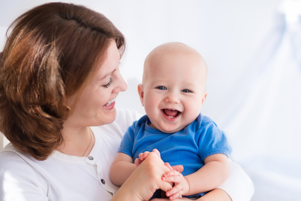 Happy mother laughing in the arms of the baby Stock Photo