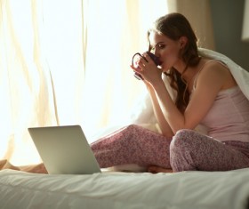Internet in bed drinking coffee woman Stock Photo