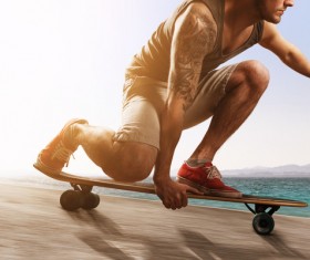 Kneeling skateboarding youth Stock Photo