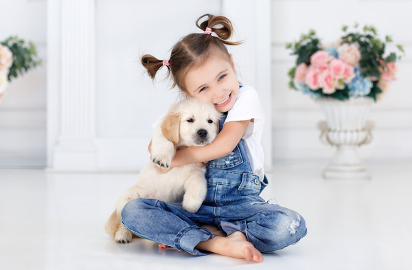 Naughty little girl holding puppy Stock Photo