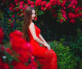 Sitting beautiful girl in red flowers Stock Photo