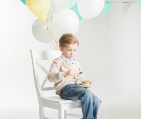 Sitting in a chair eating birthday cake boy Stock Photo