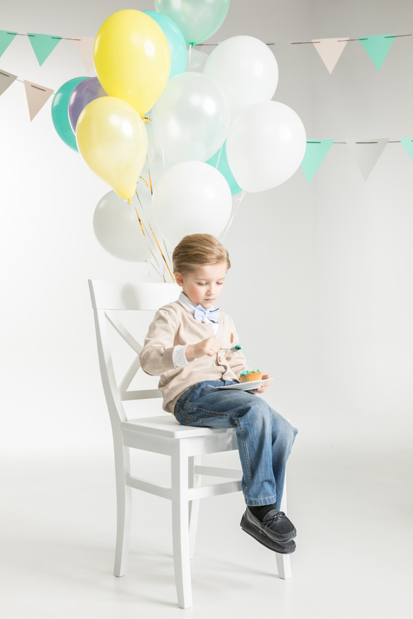 Sitting in a chair eating birthday cake boy Stock Photo