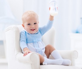 Sitting on a small sofa baby happy holding the bottle Stock Photo