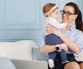 Smiling mother looking at baby in arms Stock Photo