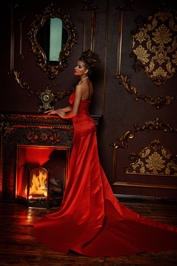 Standing in front of the fireplace red dress woman Stock Photo 01