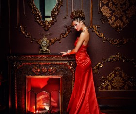 Standing in front of the fireplace red dress woman Stock Photo 02