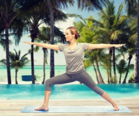 Swimming pool next to do yoga woman Stock Photo